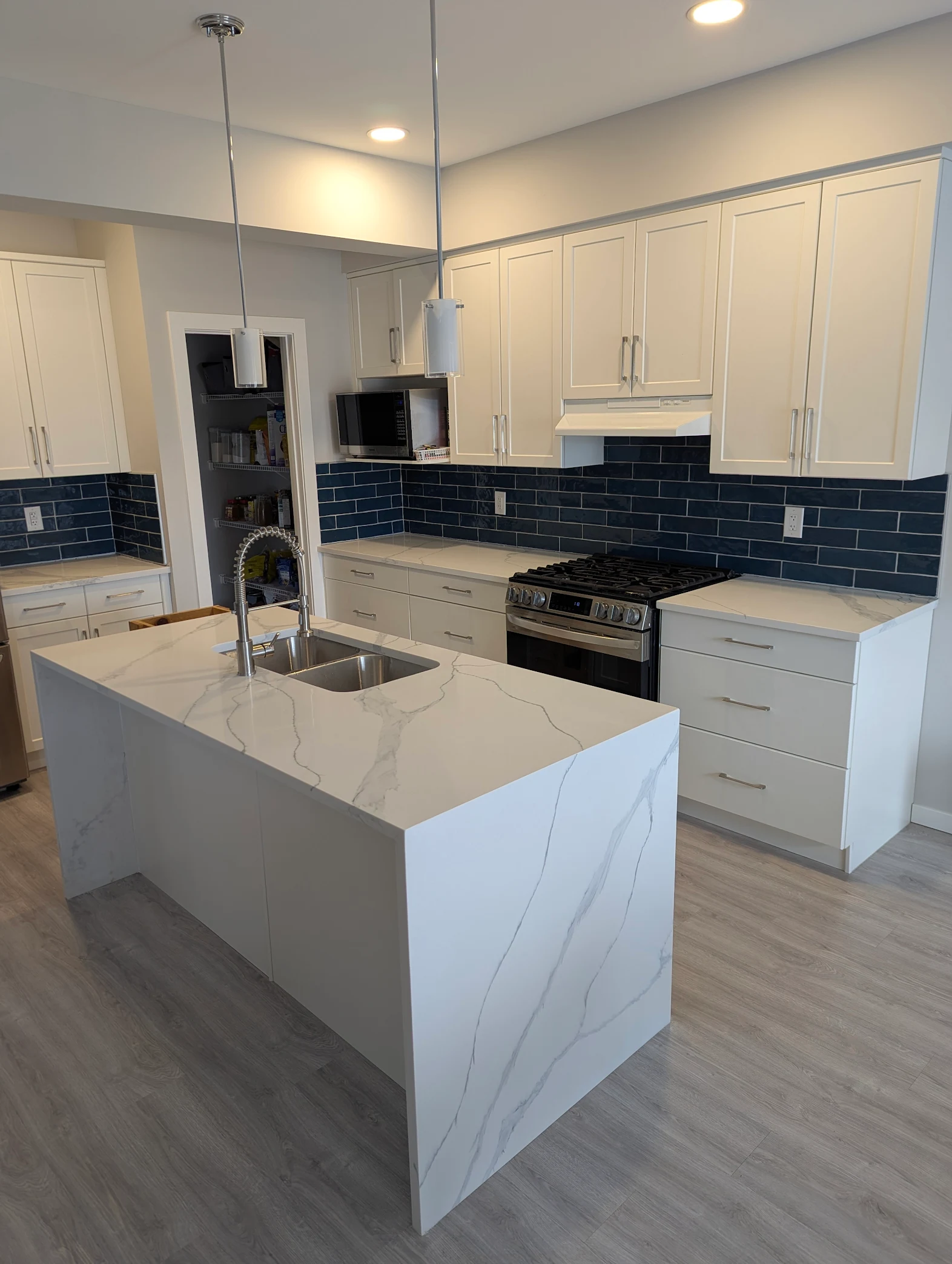 Finished kitchen with waterfall island and quartz perimeter countertops